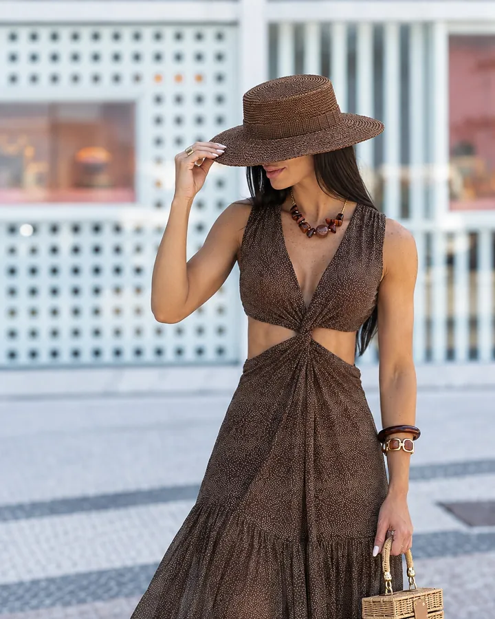 Marcela Freire com vestido longo marrom e chapéu de aba larga